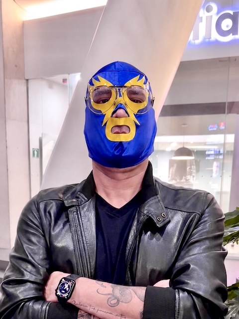 Héctor Bueno con máscara azul y dorada y chamarra negra